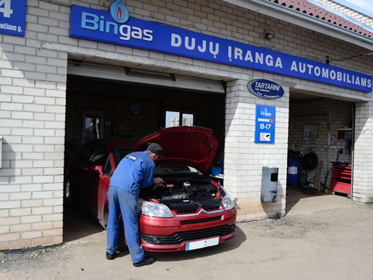 Darbuotojas atliekantis remontą — Darbuotojas dirbantis prie automobilio po kapotu atliekantis remontą